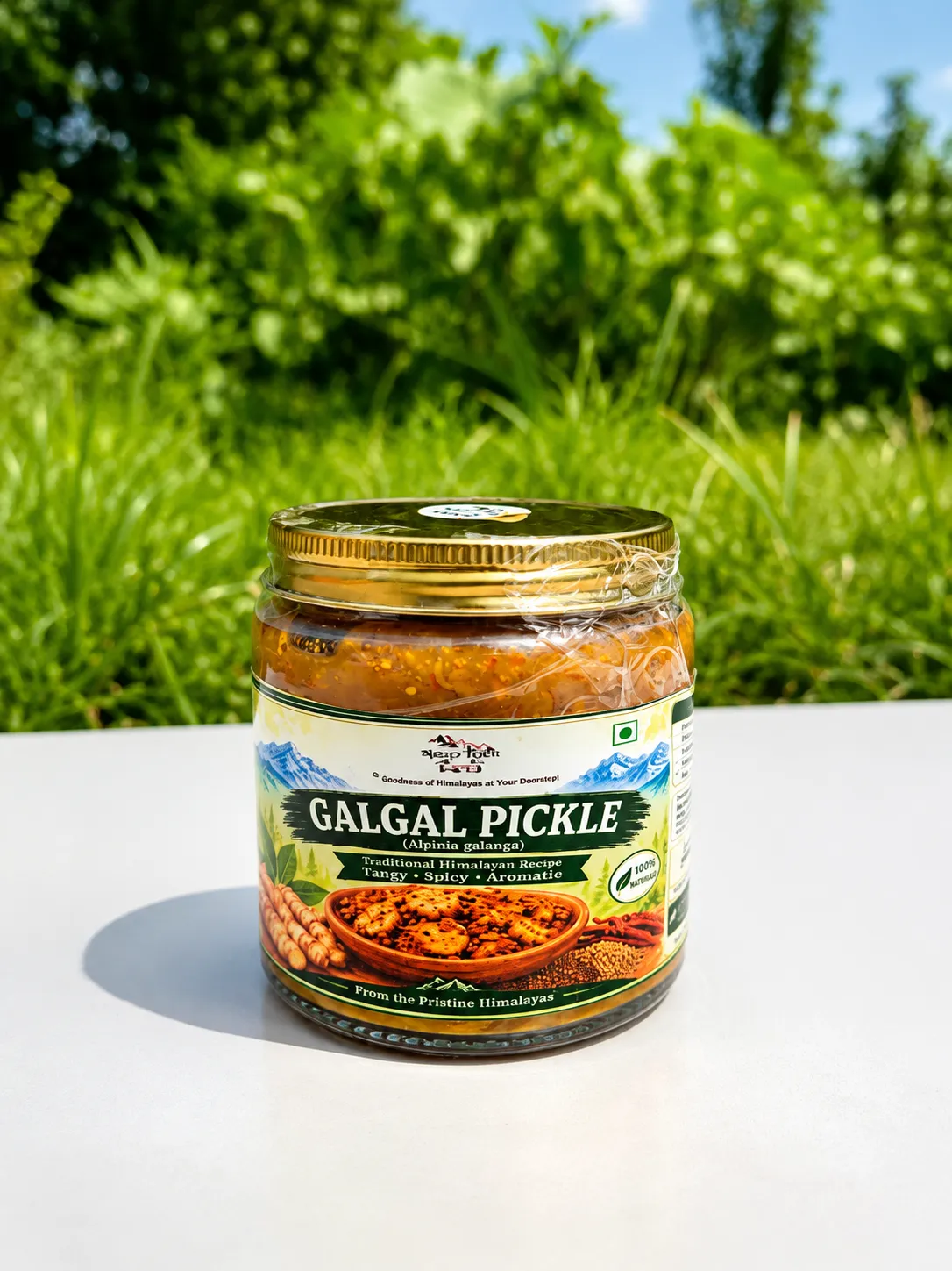 Apneehatti Galgal Pickle in a 250 g glass jar, photographed outdoors on a white surface with green Himalayan-style foliage in the background.
